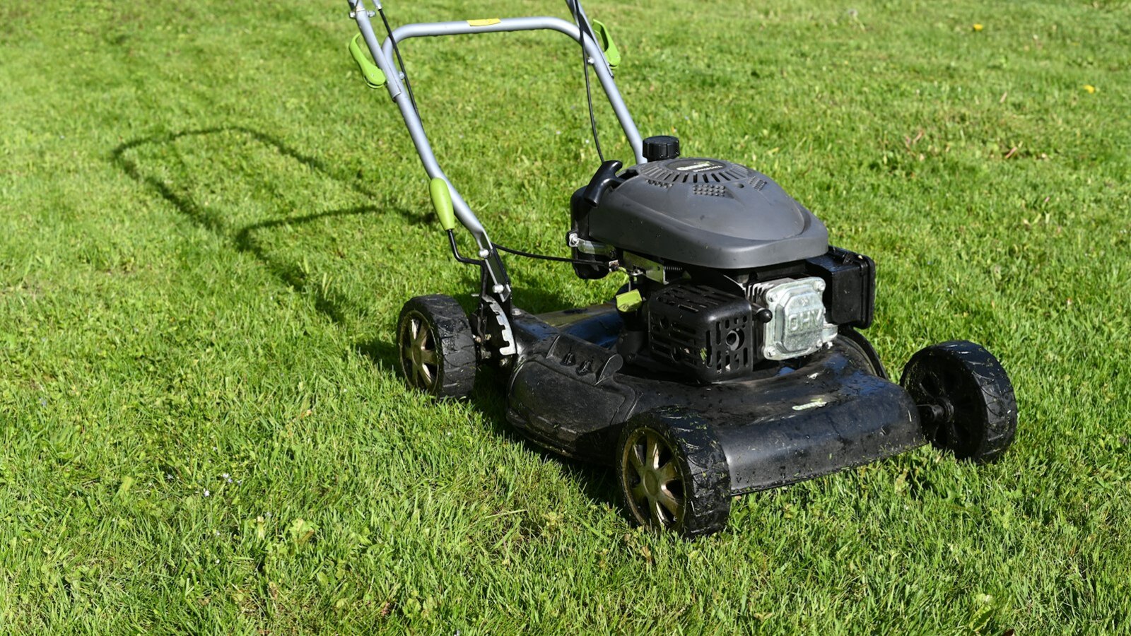 Petrol lawn mower on a freshly cut Christchurch lawn